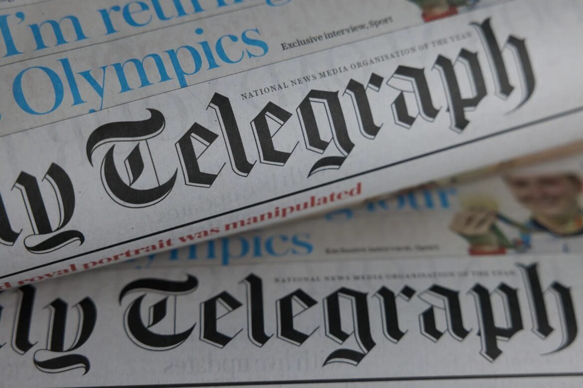Close-up of folded newspapers with the word 'Telegraph' in black Gothic type and blue 'Olympics' headline visible on the pages, newspapers stacked together.