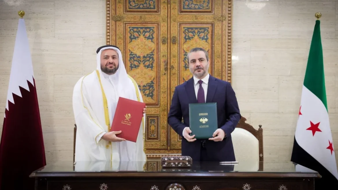 Two men sign an official agreement at a desk, each holding a colored folder (red and green) with national flags (Qatar and Syria) in the background.