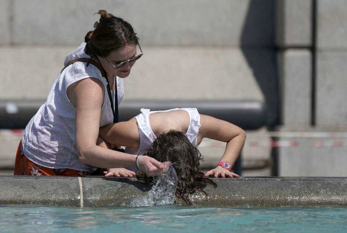 Woman helping a child wash hair at the pool edge, water splashing from the faucet onto the child’s hair.