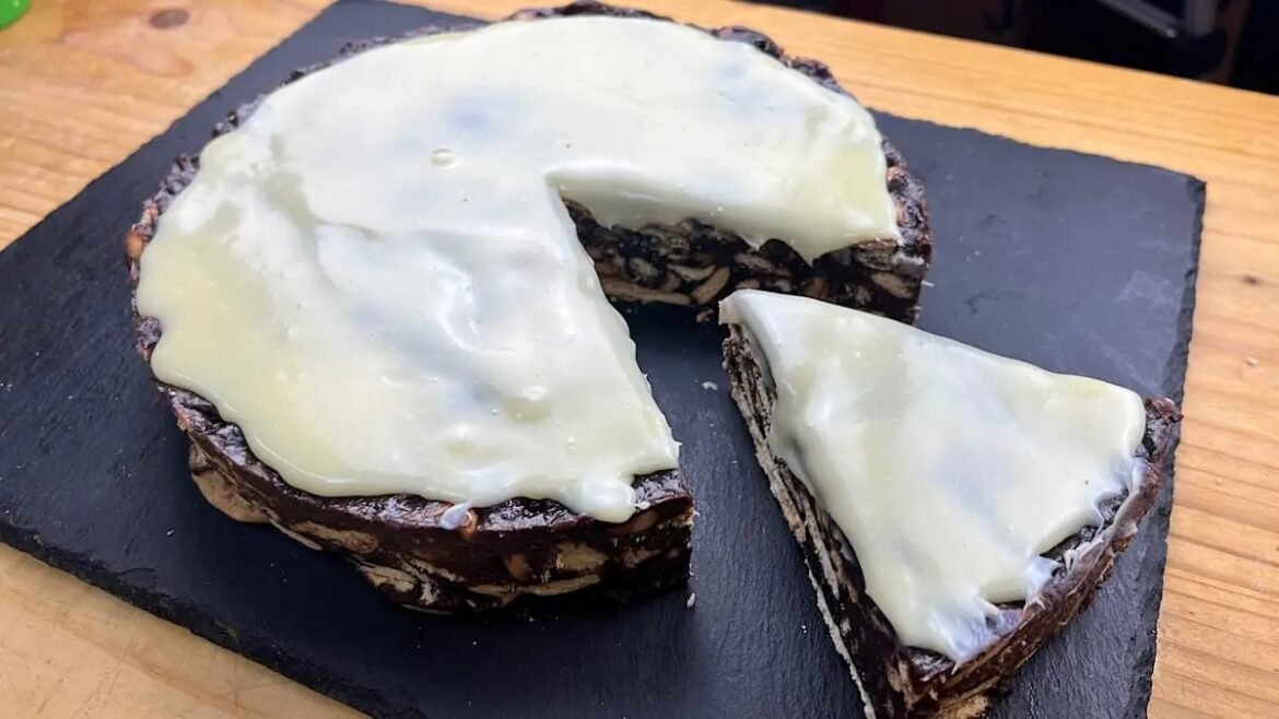 Chocolate zebra cake with white glaze, sliced on a dark slate platter.