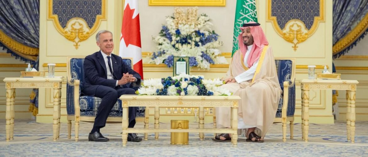 Two dignitaries in a gold-trimmed room share a formal meeting, seated across from each other with a floral centerpiece and flags in the background.