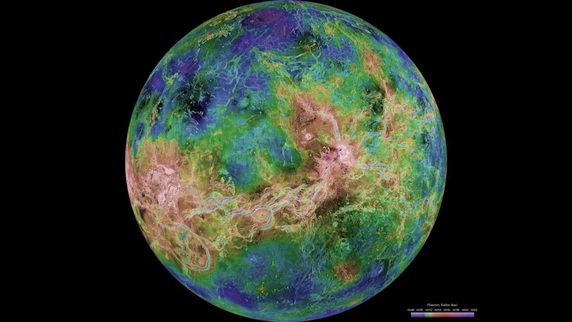 False-color global map of Venus showing topography on a dark background, with a rainbow color scale and a planetary radius legend at the bottom.