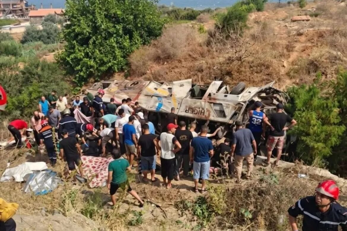 Crowd of rescuers and bystanders at an overturned bus on a dry, rocky hillside, with rescue blankets and equipment nearby