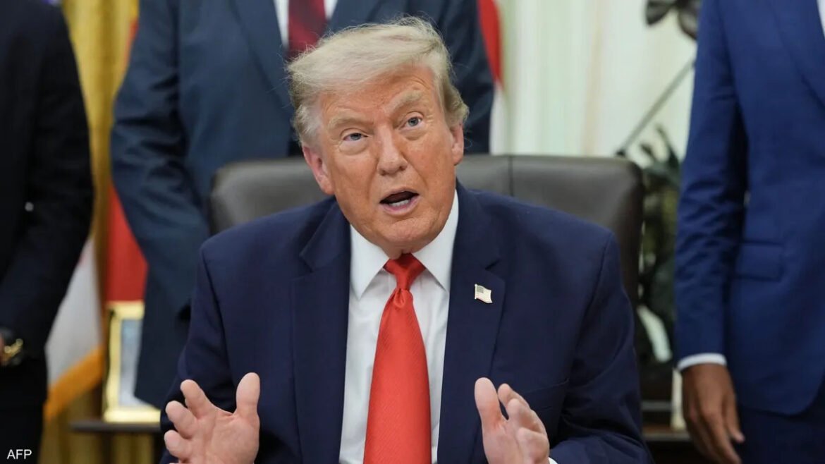 Donald Trump in a dark suit and red tie speaking and gesturing with his hands in a meeting setting
