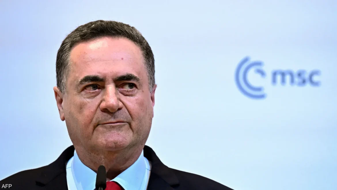 Close-up of a middle-aged man in a suit speaking into a microphone at a press event, with a light blue backdrop and partial logo visible in the background.
