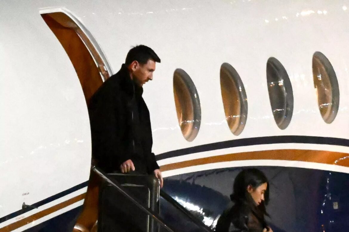 Man and woman descend the stairs from a white private jet with round windows along the fuselage