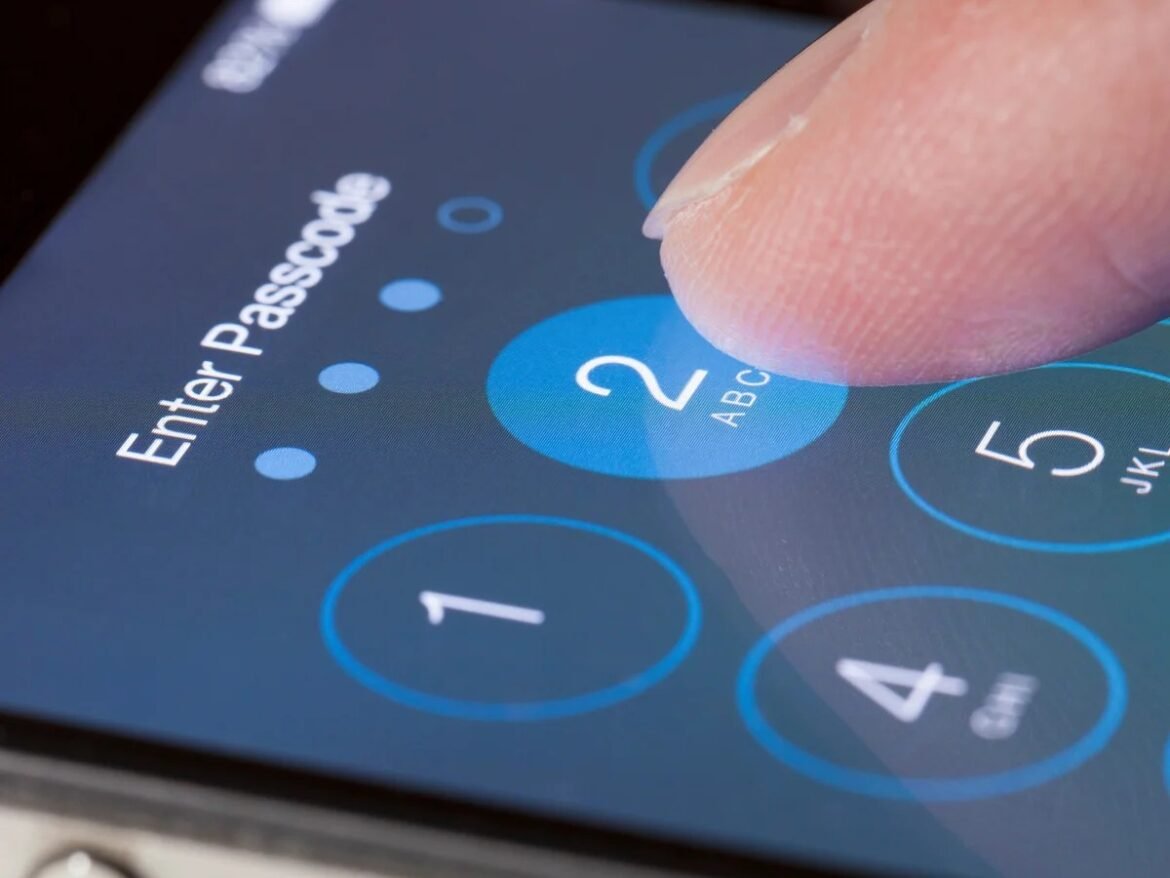 Finger taps a blue circular number 2 on a smartphone passcode keypad with 'Enter Passcode' text visible.
