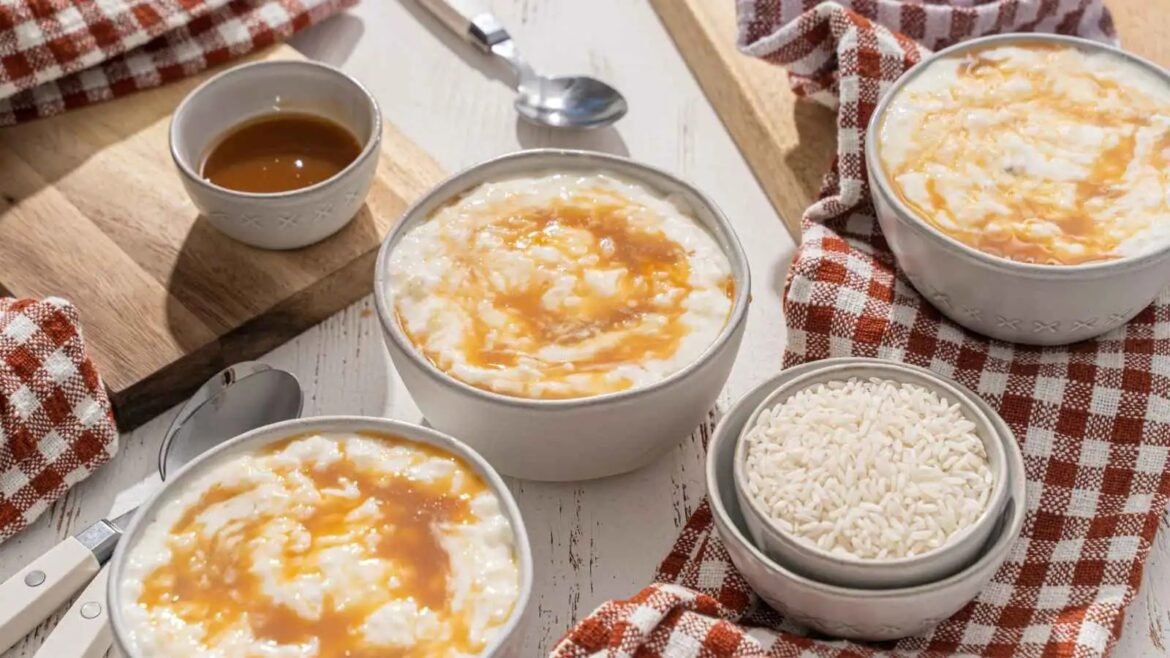 Bowls of creamy rice pudding with caramel drizzle, served in white bowls on a rustic wooden board with red-and-white checkered cloths.
