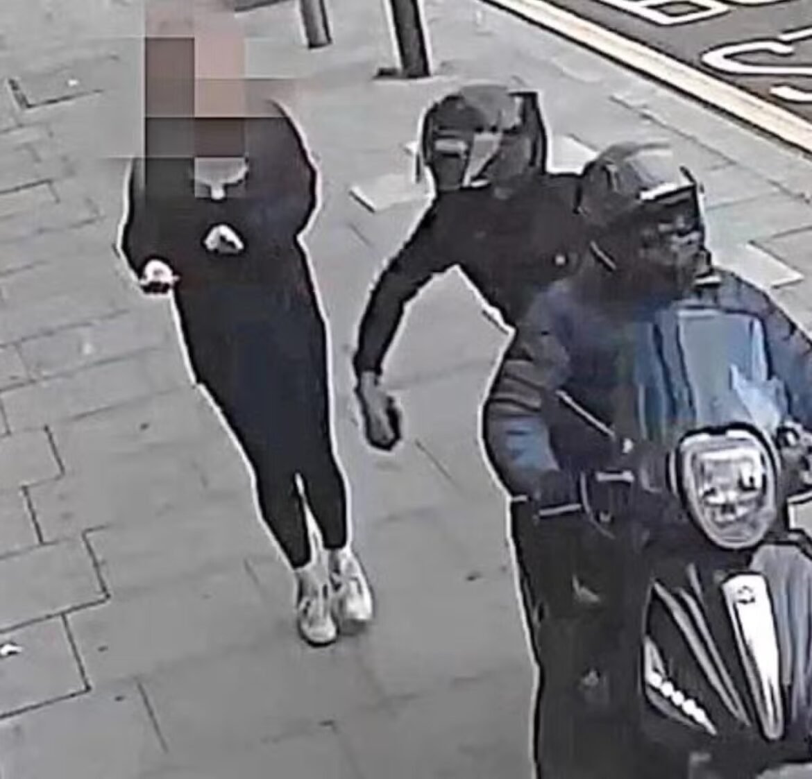 Person with a pixelated face wearing a dark hoodie and white sneakers walking on a sidewalk beside a person on a blue scooter or motorcycle with a helmet.