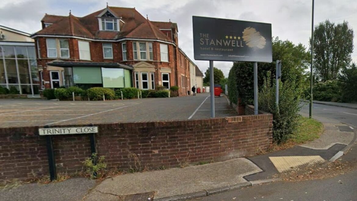 Brick hotel building with a large The Stanwell hotel & restaurant sign, in front of a brick wall bearing Trinity Close signage.