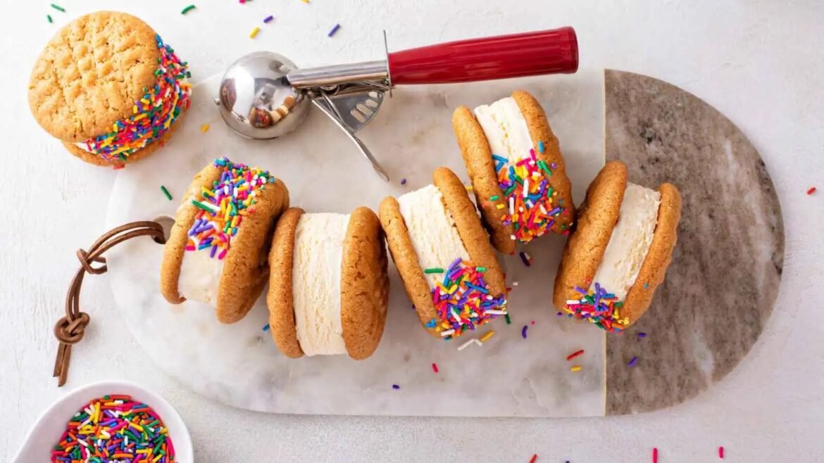 Stack of ice cream sandwich cookies with vanilla filling and rainbow sprinkles on the edges.