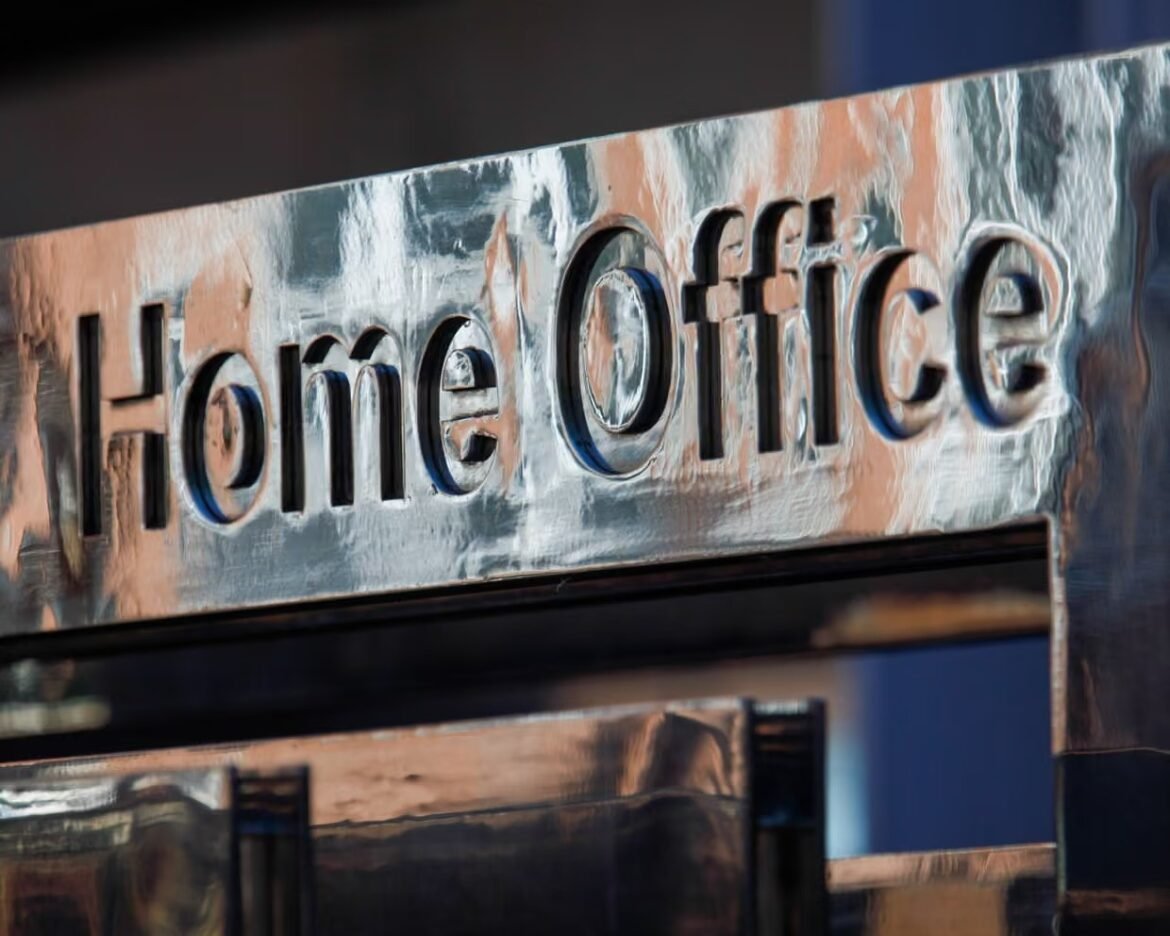 Close-up of a metallic sign reading 'Home Office' with a reflective, silver surface.