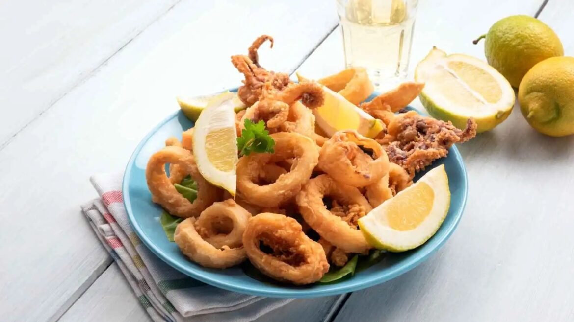 Crispy fried calamari rings with lemon wedges on a blue plate, garnished with parsley
