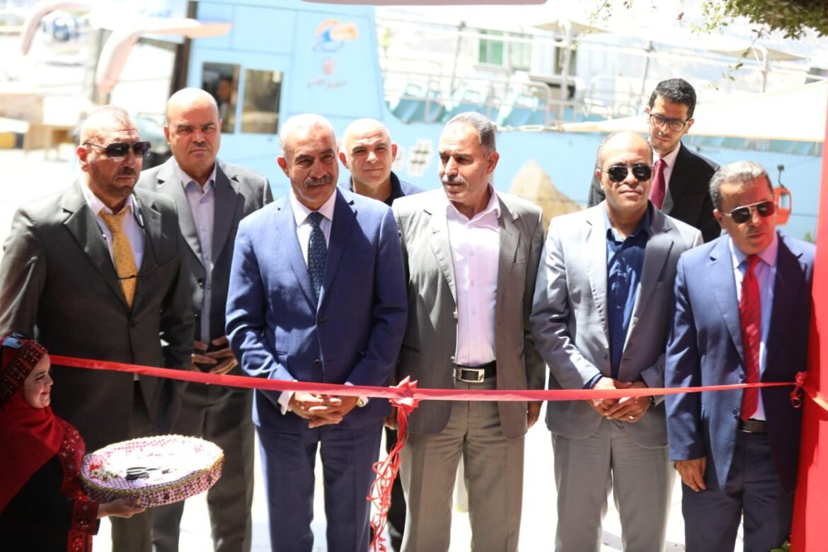 Group of suited men at a ribbon-cutting ceremony, one ready to cut the red ribbon while others watch.