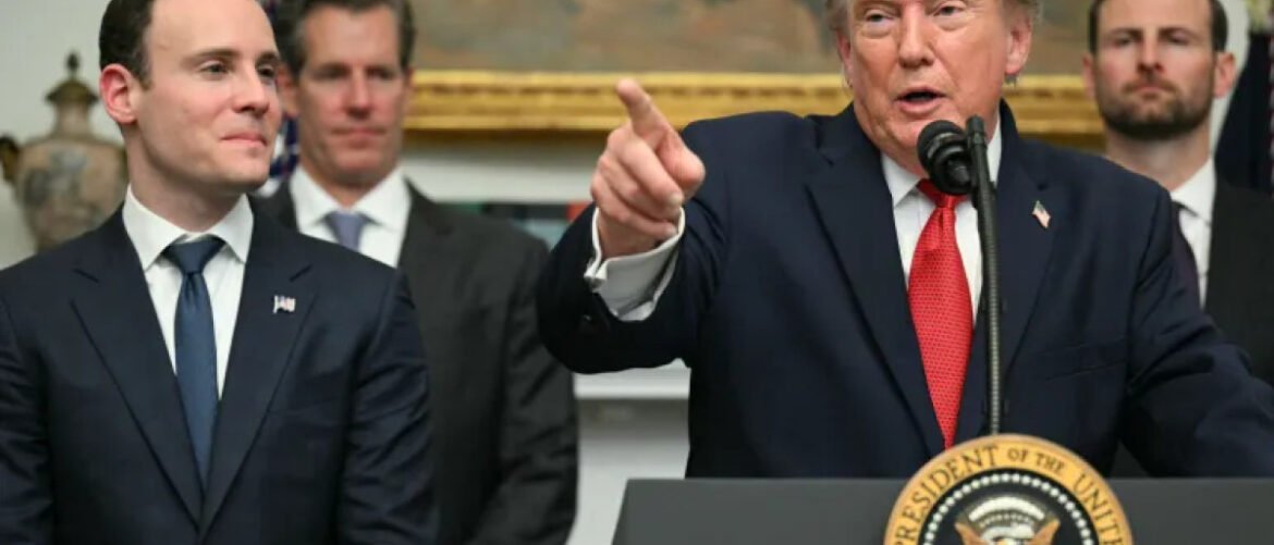 President at a podium, pointing while speaking, with aides standing behind him in a formal press event.