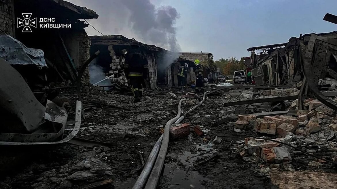 Firefighters in protective gear search through rubble after a building collapse, with smoke rising and damaged structures around a ruined street.