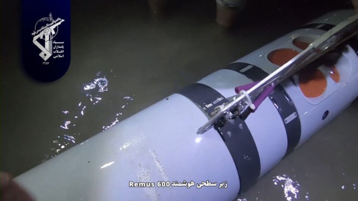 Submerged Remus 600 ROV attached to a torpedo-shaped device in murky water, with Persian subtitles mentioning 'Remus 600'.