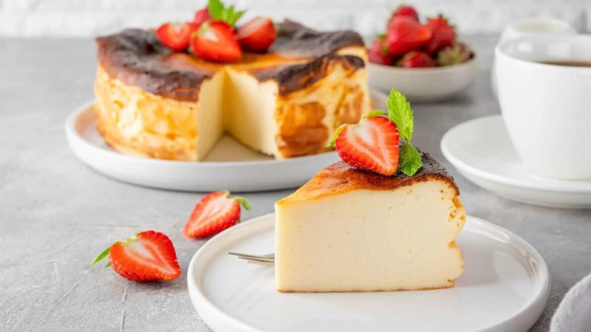 Creamy cheesecake slice with a toasted top, garnished with a strawberry half and mint on a white plate.