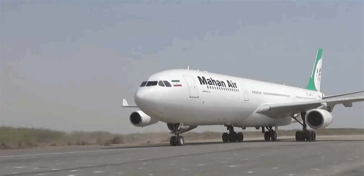 White Mahan Air passenger aircraft on the runway, facing forward, with a green-tail livery.