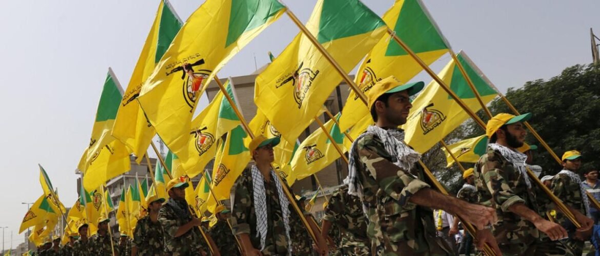 Group of camouflaged soldiers marching in a parade while waving bright yellow flags with emblems.