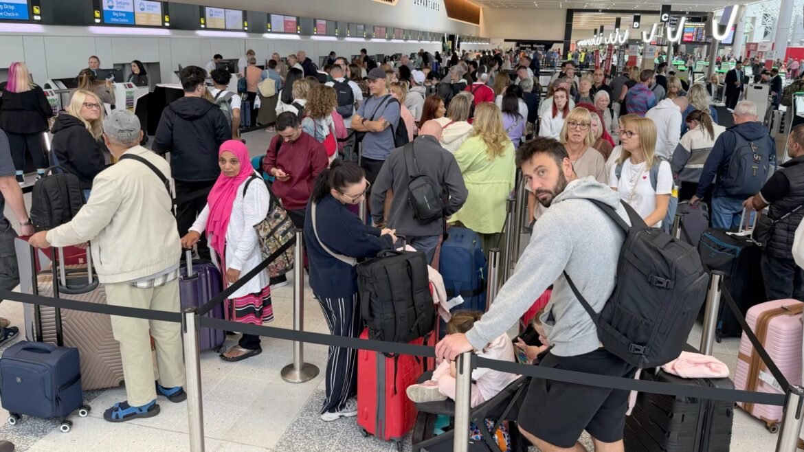Crowded airport check-in area with long lines of travelers and rolling luggage awaiting service. (Informative)