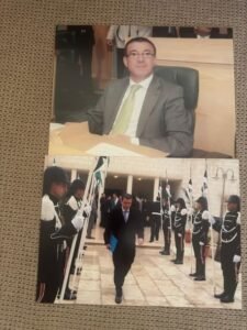793518548280890723740849044866952879662874295n 1 | Aleumumnews Two photo Collage Top Image Shows a Man in a Gray Suit and Lime green Tie Seated at a Desk in an Office Bottom Image Shows a Man in a Dark Suit Walking Through a Formal Guard of honor Lineup Outside a Building Aleumumnews