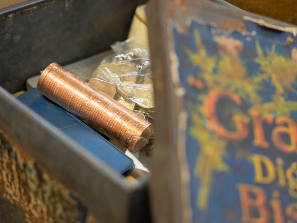 Rolls of copper pennies in a coin drawer next to loose coins in a plastic bag.