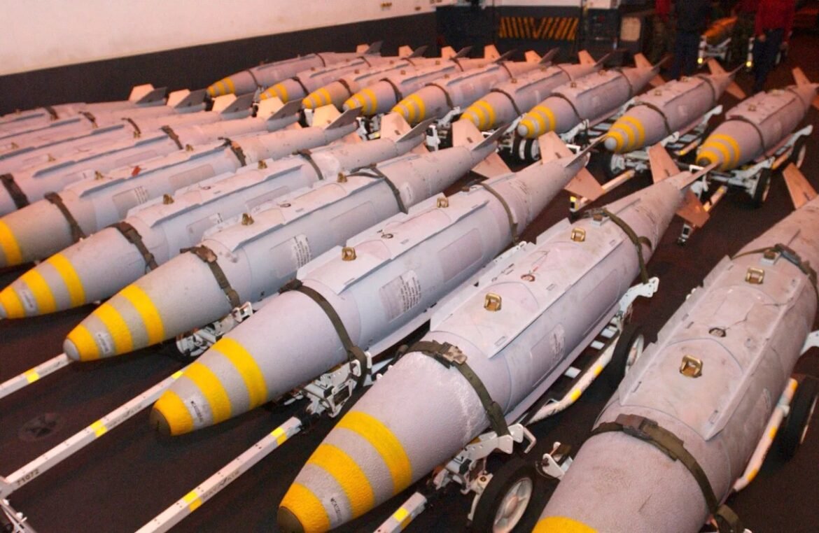 Rows of gray missiles with yellow noses lined up on a ship’s deck, strapped to launch pylons.