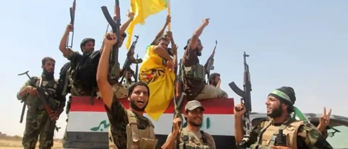 Armed fighters atop a vehicle draped with an Iraqi flag, raising rifles and hands in celebration in a desert setting.