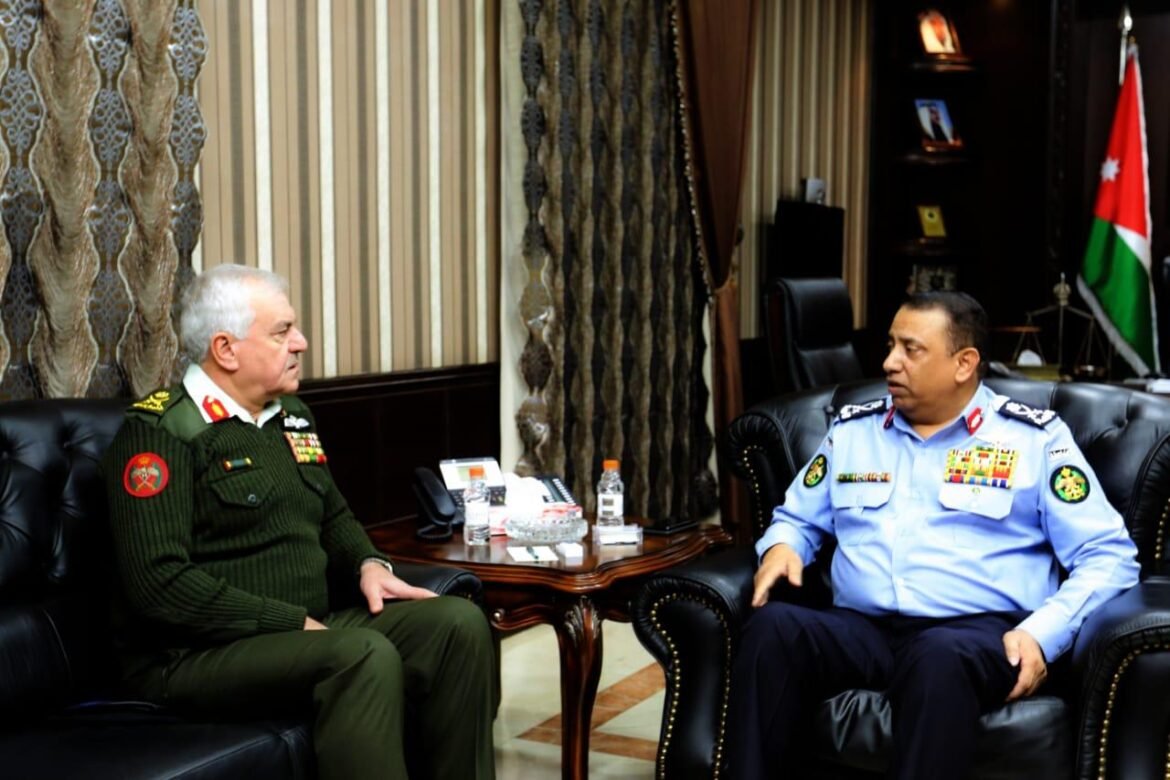 Two high-ranking military officers in formal uniform sit on leather chairs across a small table in a plush office, Jordan flag in the background.