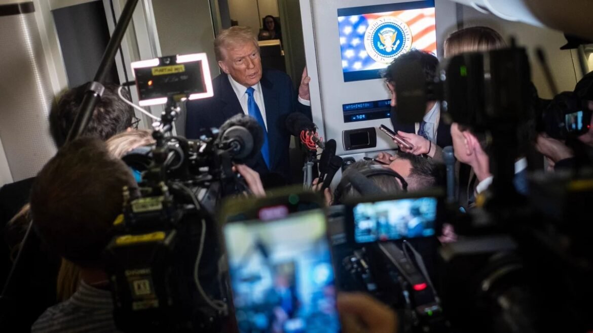 Former President Donald Trump surrounded by reporters and cameras in a press scrum.